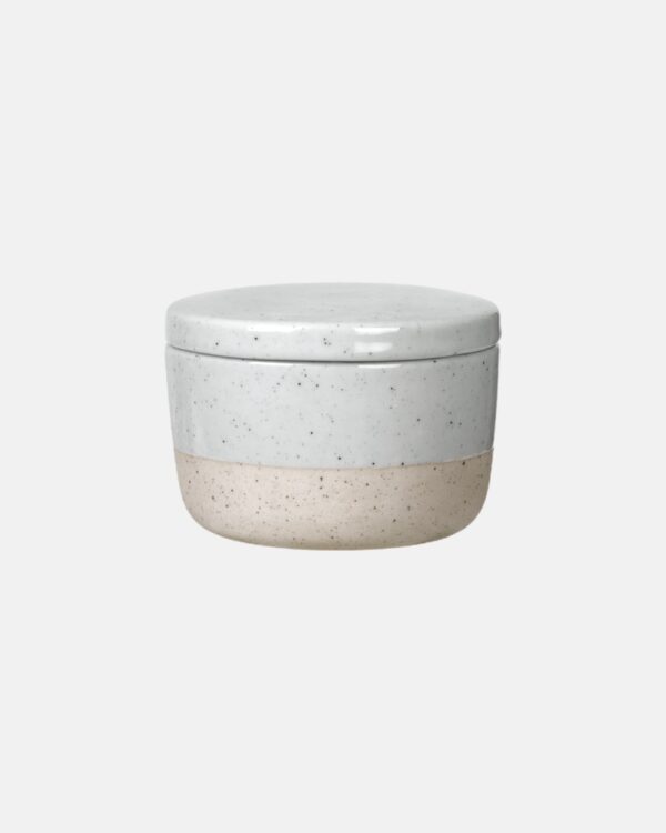 Soft and rough – like water flowing over sand. The SABLO ceramic sugar bowl with lid is made of a mixture of coloured clay, quartz, minerals and oxides. The lightly speckled look perfectly complements the colour combination of grey and beige tones, and is texturally reinforced by the partial glaze. Due to variations in colour, each piece is one-of-a-kind with a unique hand-crafted appearance. Dishwasher and microwave-safe.