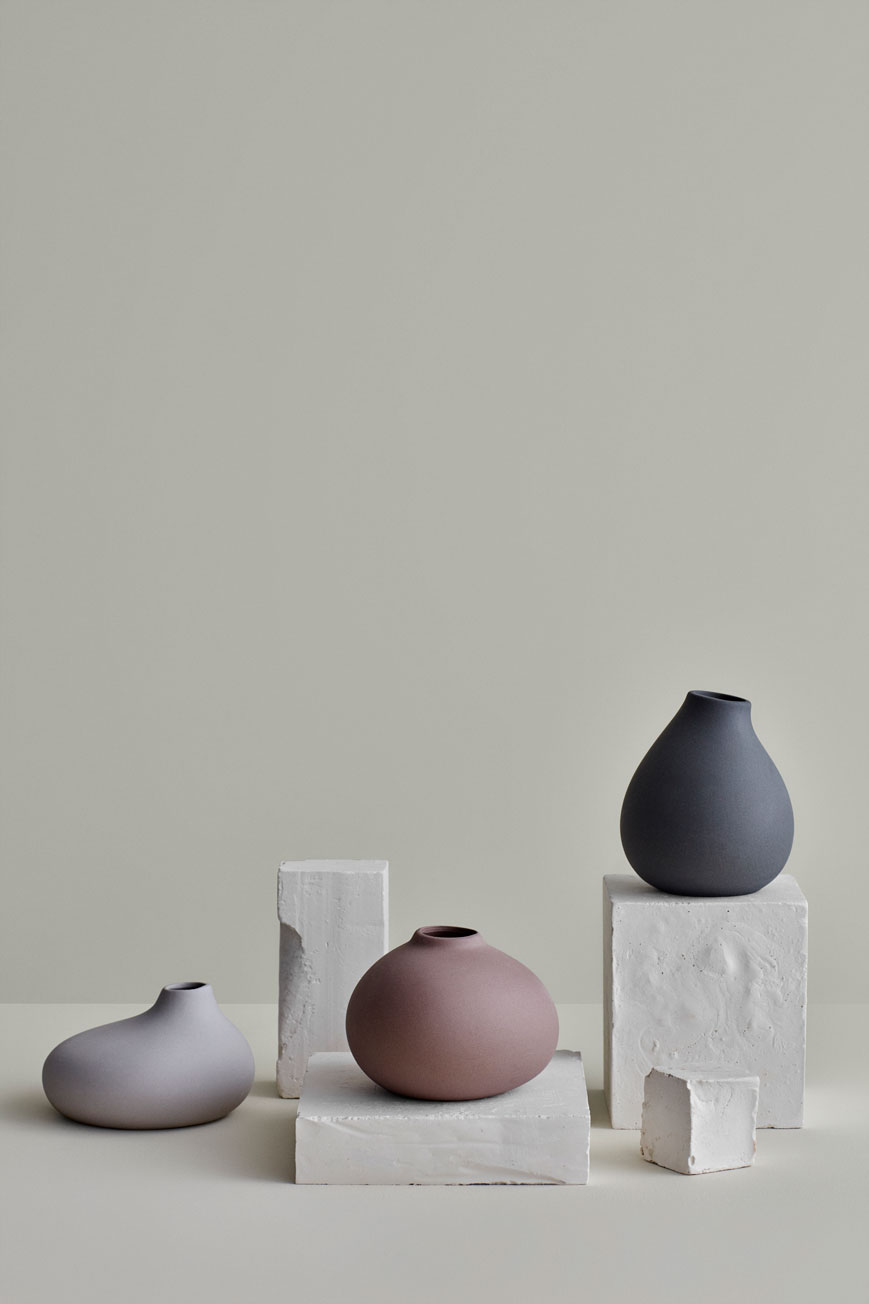 3 different vases in grey, pink and white colour on rectangle white stones