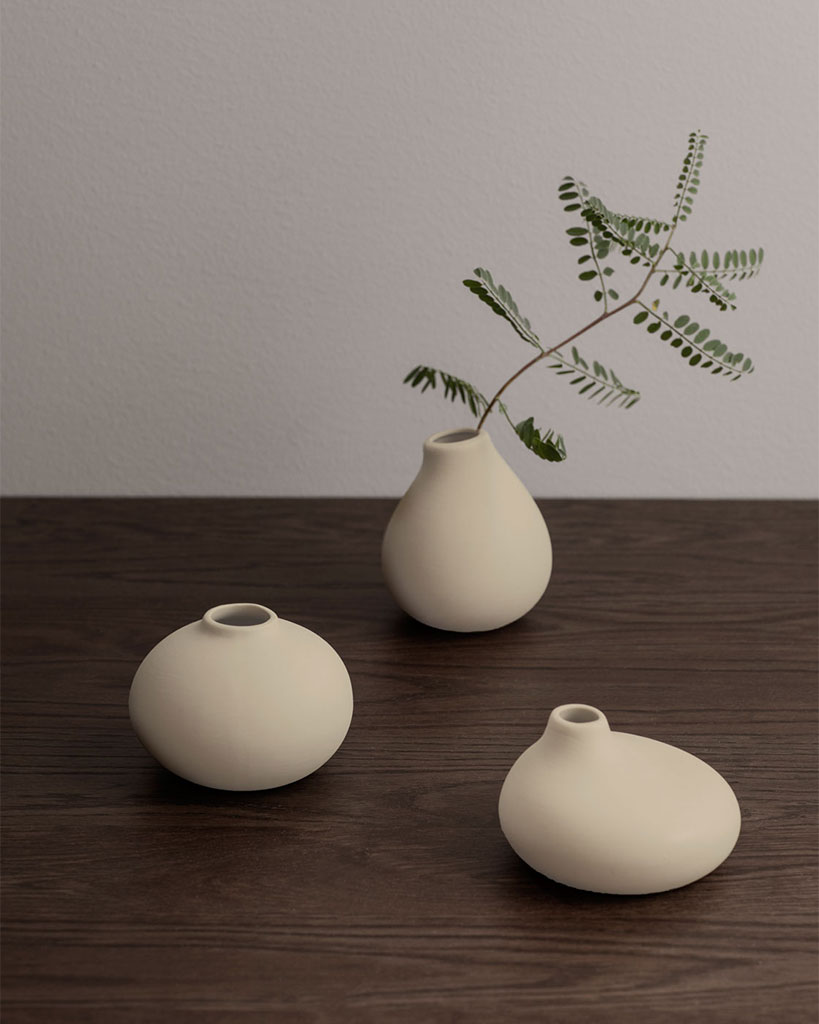 Three unglazed porcelain vases in a "Vanilla" color with a natural, organic shape. Each vase has slight variations in color and texture, creating a unique and charming set. Perfect for displaying flowers or adding a touch of earthy elegance to your home decor.
