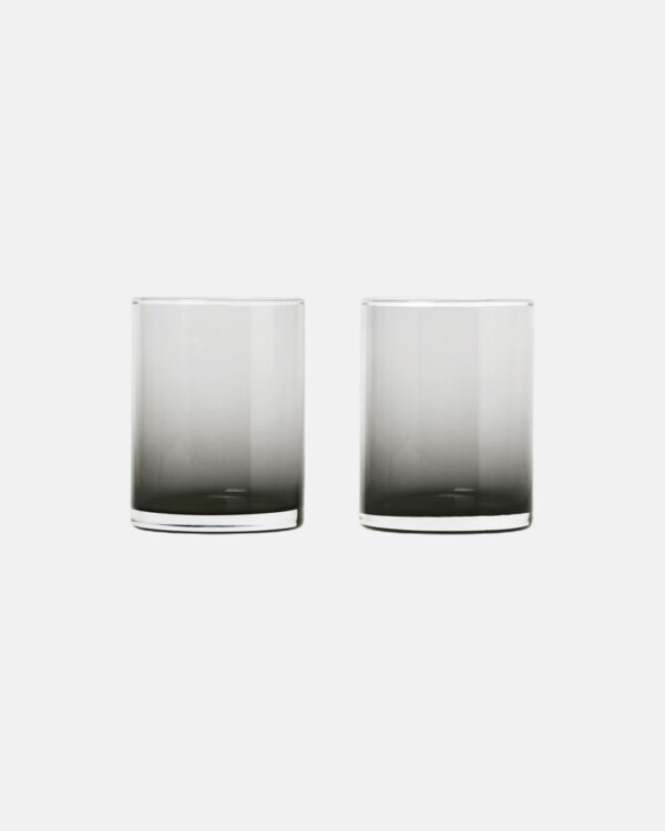 smokey drinking glasses next to a marble sink and on top of a hand-towel.