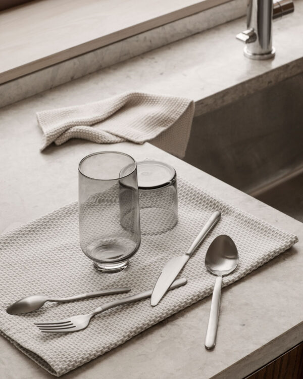 smokey drinking glasses next to a marble sink and on top of a hand-towel.