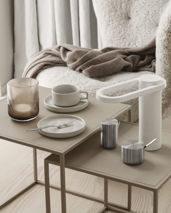living room table with a lantern in coffee colour along side with a table light and coffee mug