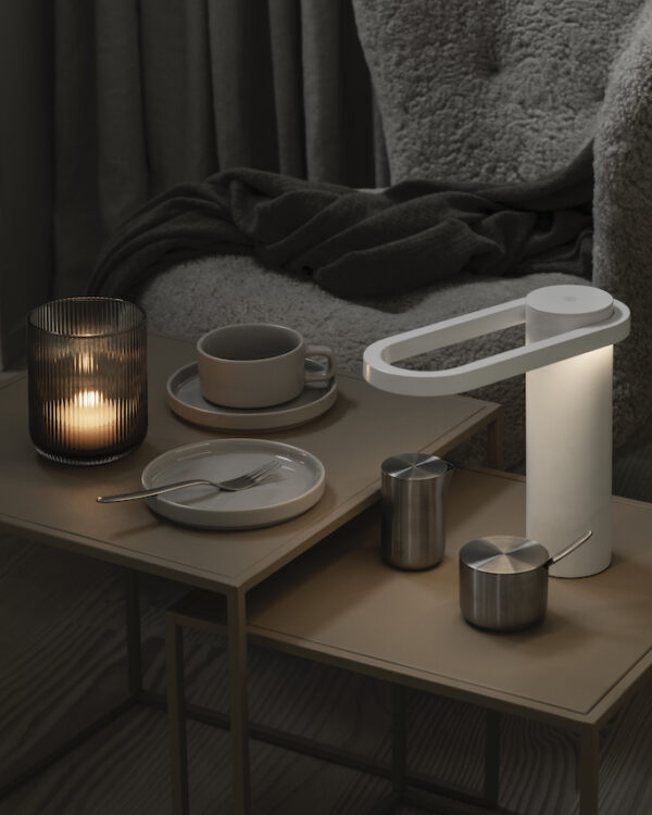 living room table with a lantern in coffee colour along side with a table light and coffee mug