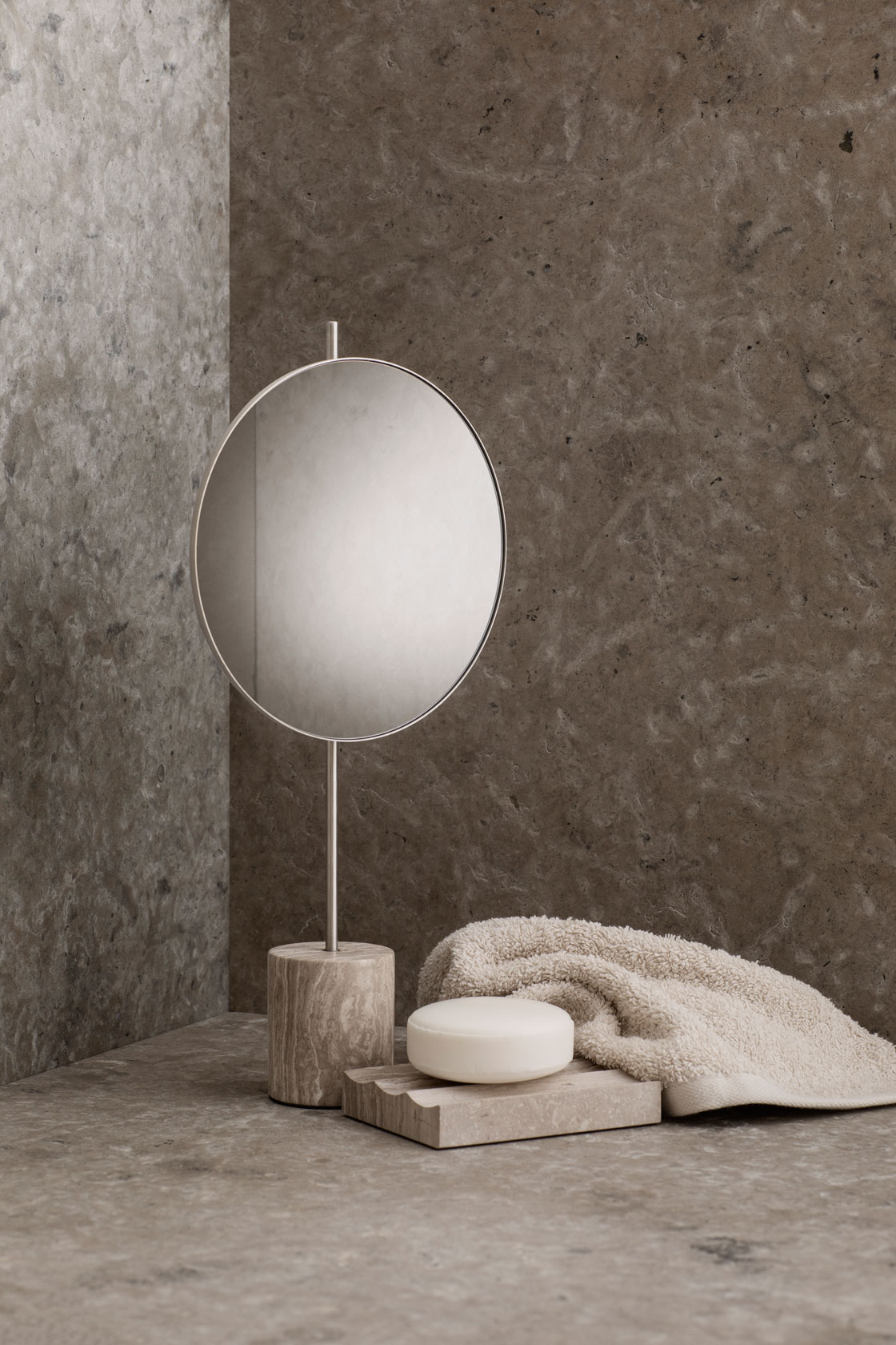 a marble soap holder and a soap holder in a corner with a vanity mirror and a beige towel
