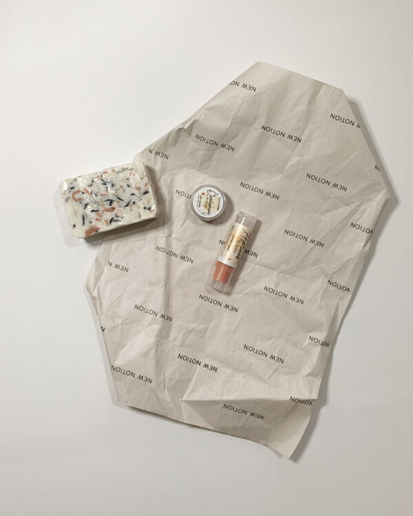 a flatlay of a gift box including a soap, a lip scrub and a lip balm all made with natural ingredients