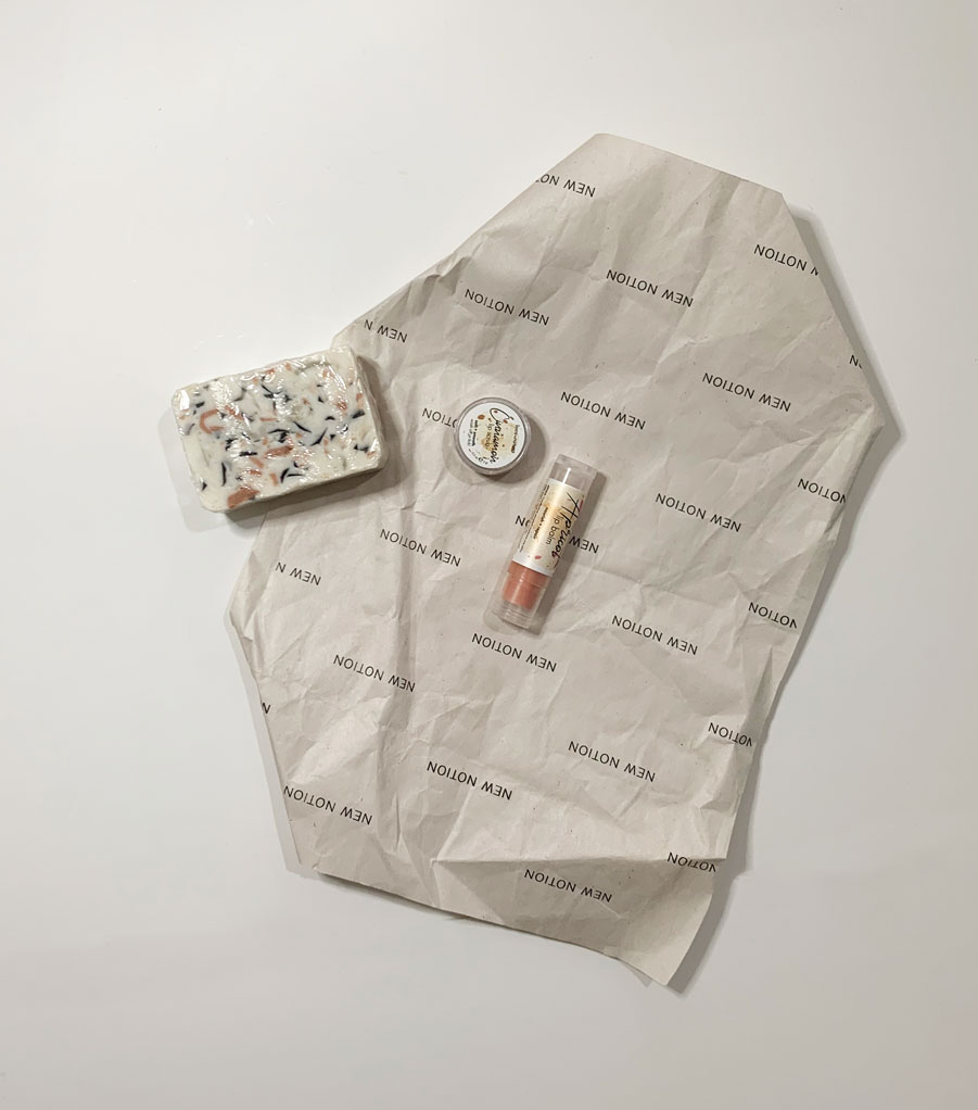 a flatlay of a gift box including a soap, a lip scrub and a lip balm all made with natural ingredients
