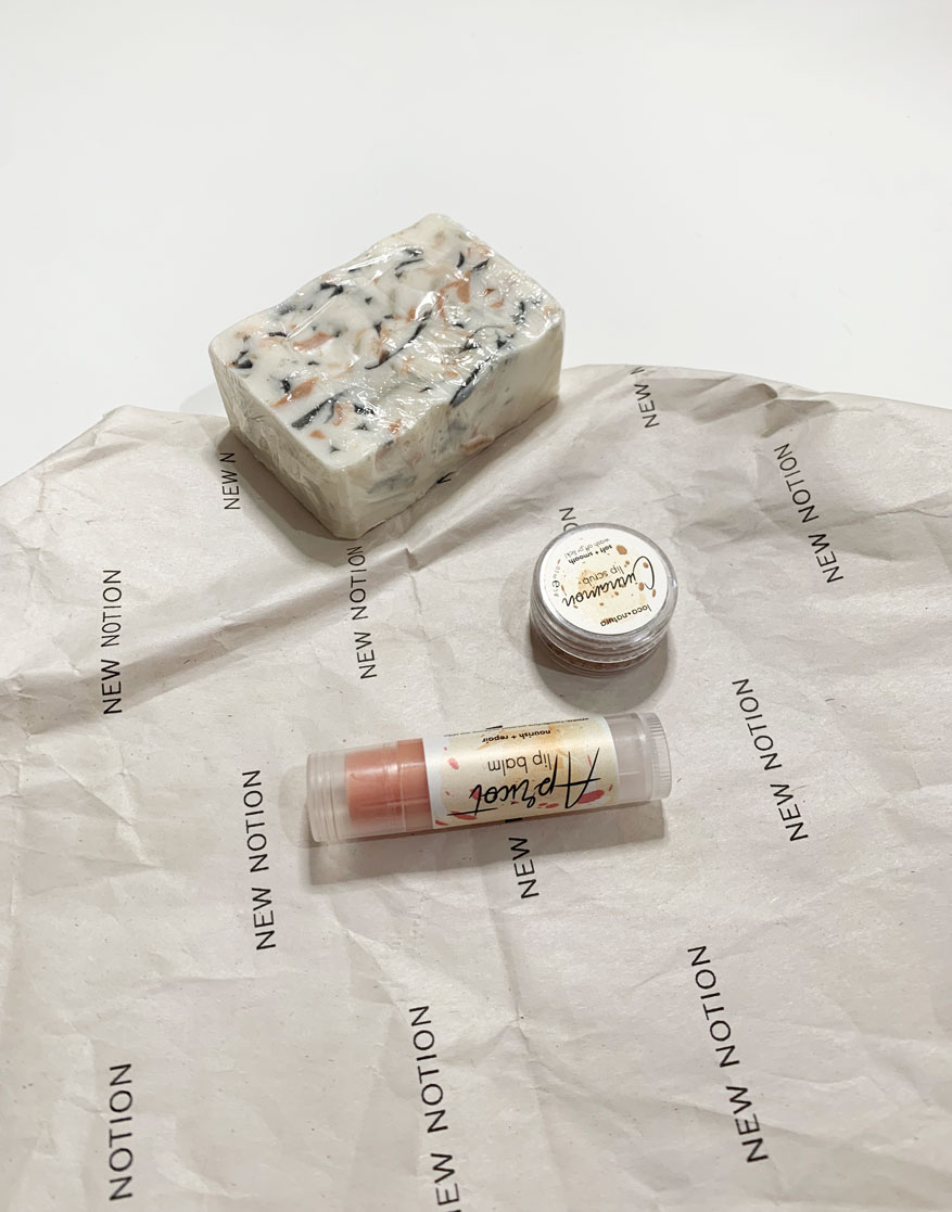 a flatlay of a gift box including a soap, a lip scrub and a lip balm all made with natural ingredients