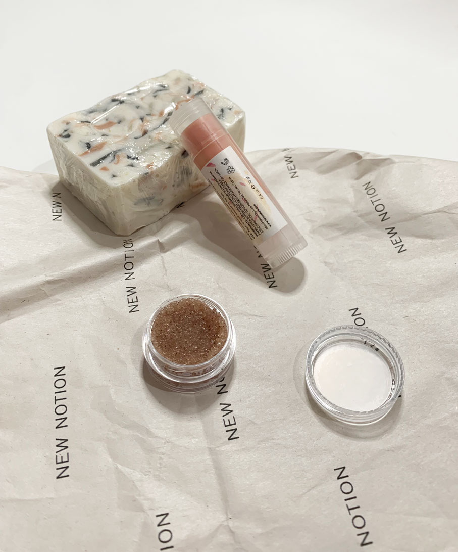 a flatlay of a gift box including a soap, a lip scrub and a lip balm all made with natural ingredients