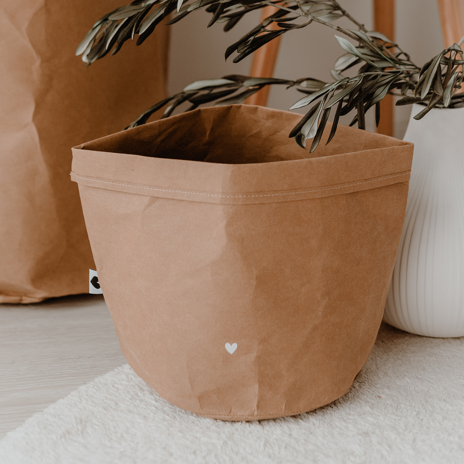 paper baskets in black colour. This set consists of two paper bags in different sizes. The larger paperbag is decorated with a heart. The smaller one bears the saying "It's the little things in life" in German.