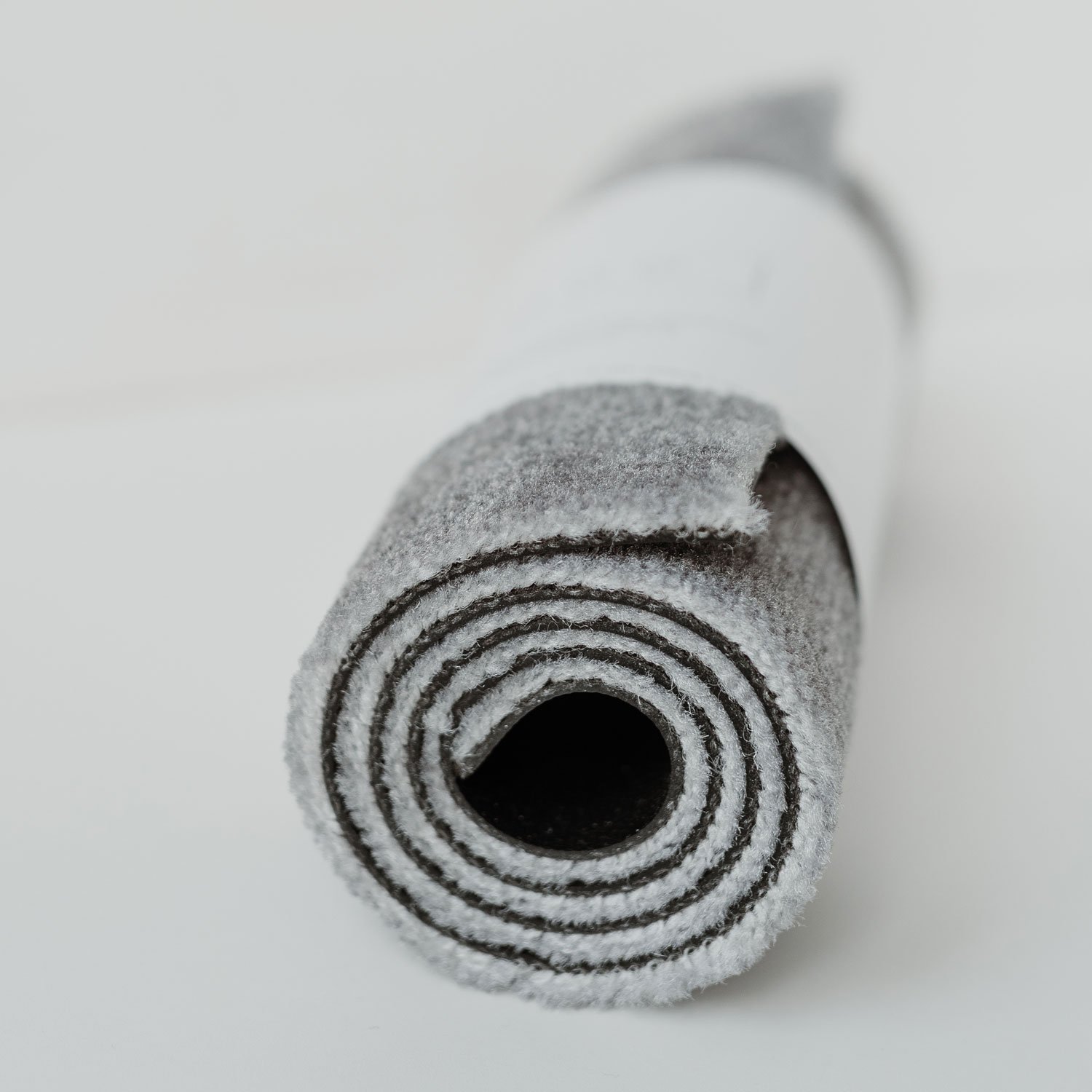 a grey doormat with 3 white hearts on it. 75cm x 25cm.
