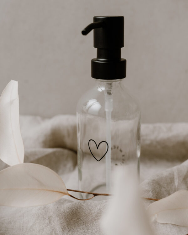 glass soap dispenser with an outline of a black heart engraved