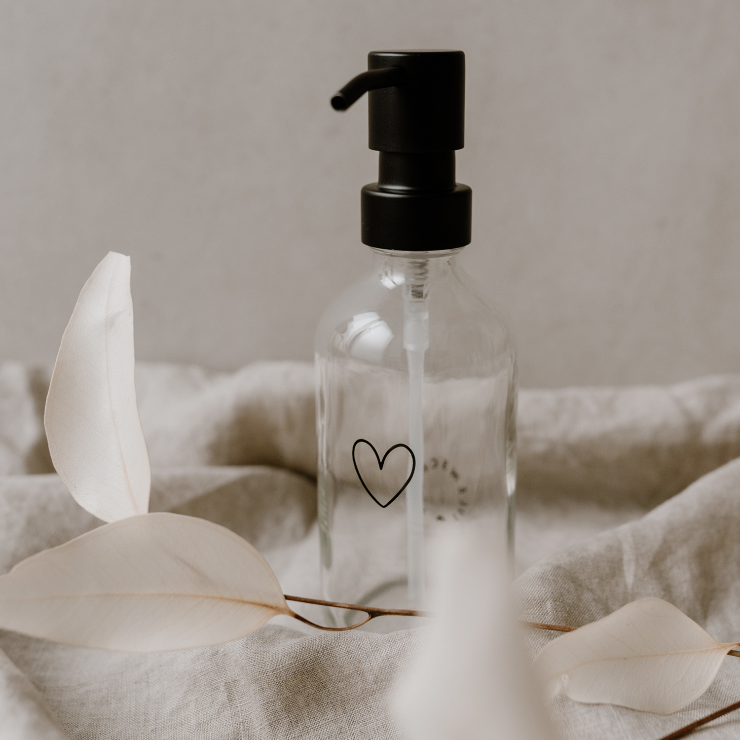 glass soap dispenser with an outline of a black heart engraved
