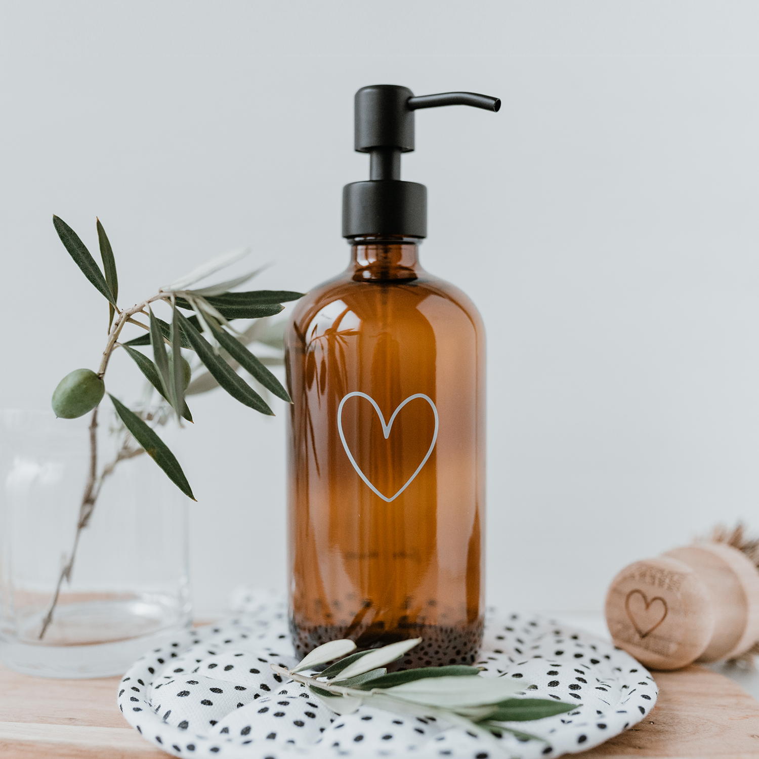 amber glass soap dispenser with an outline of a white heart engraved