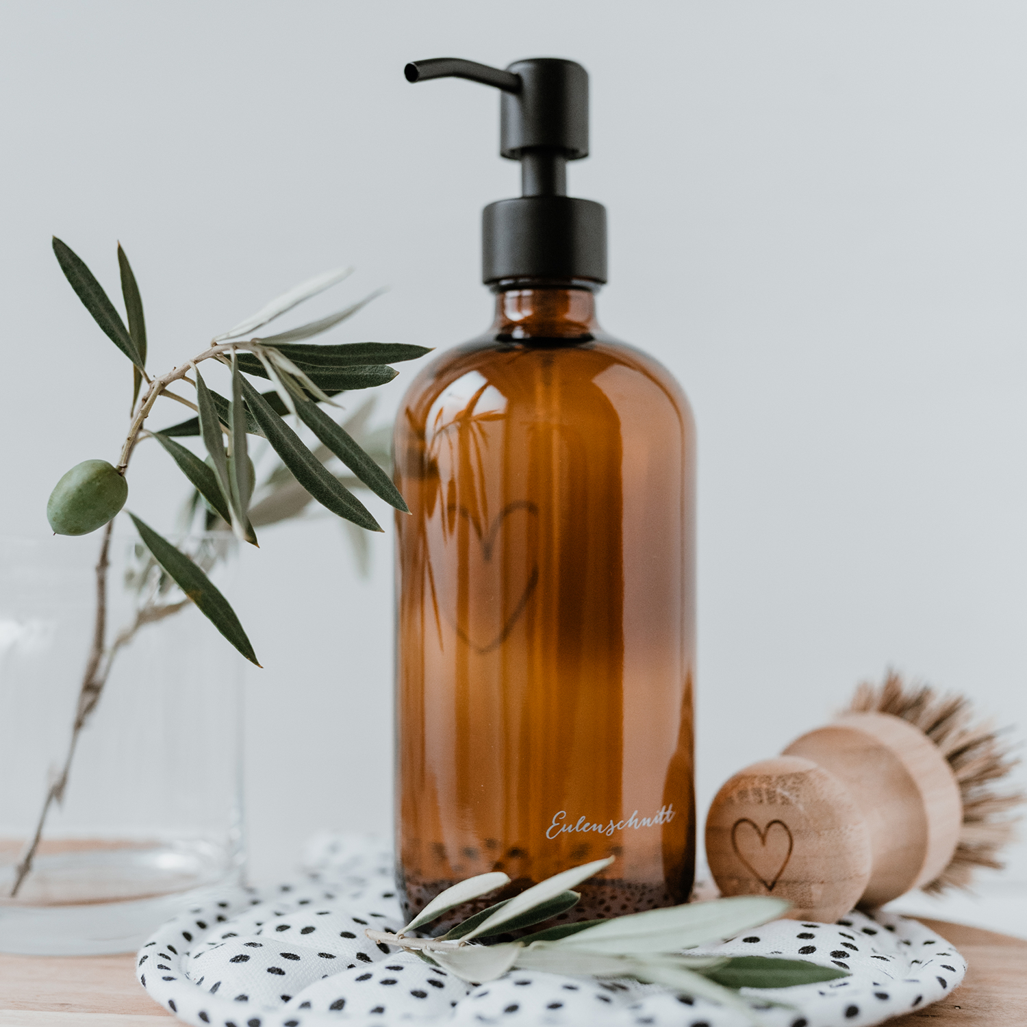amber glass soap dispenser with an outline of a white heart engraved