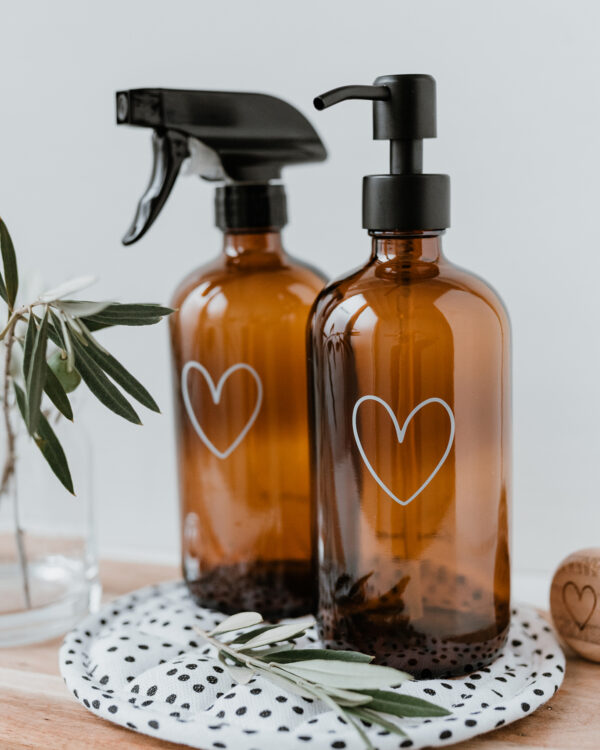 amber glass soap dispenser with an outline of a white heart engraved