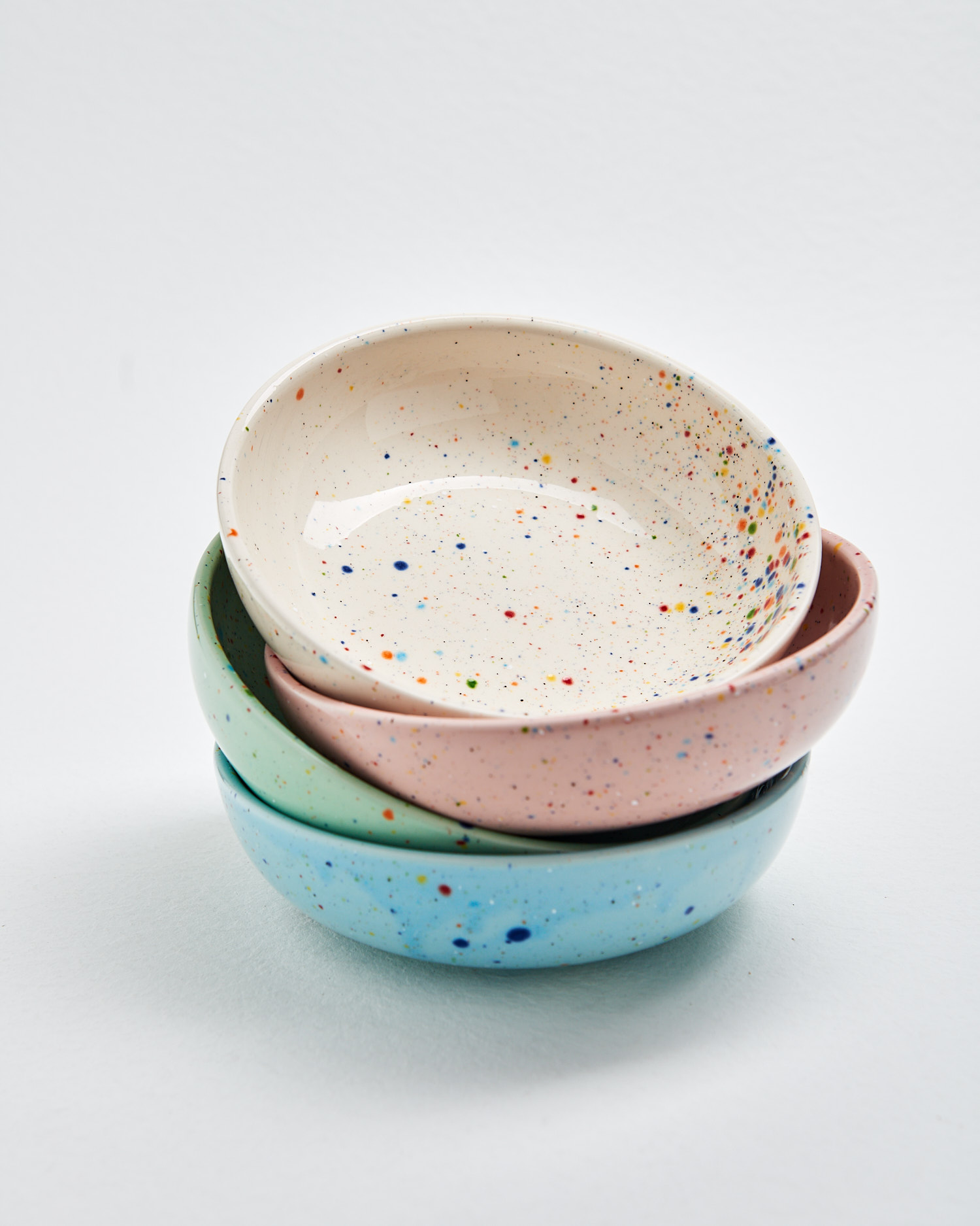 A collection of modern pasta bowls in various bright colors.