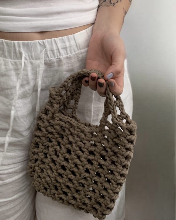 Close-up of a beautiful ASH-BEIGE crochet bag with a mesmerising mesh pattern. Perfect for a stylish and chic look.