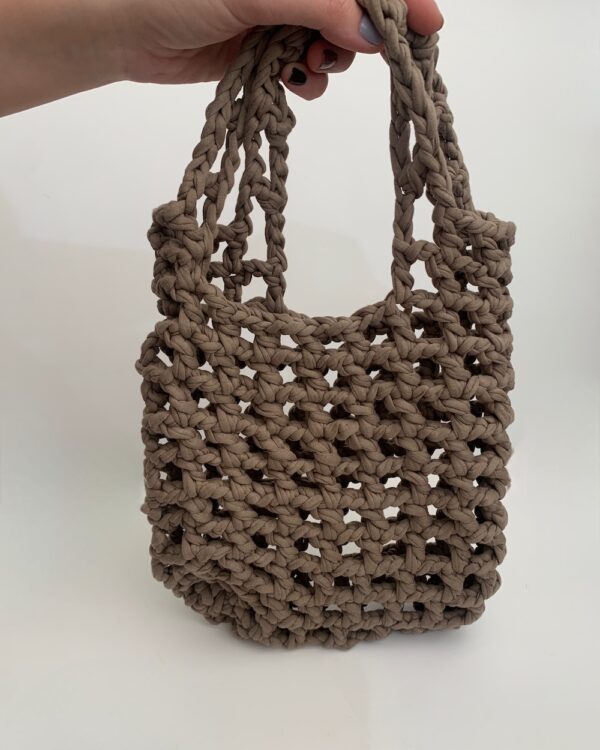 Close-up of a beautiful ASH-BEIGE crochet bag with a mesmerising mesh pattern. Perfect for a stylish and chic look.