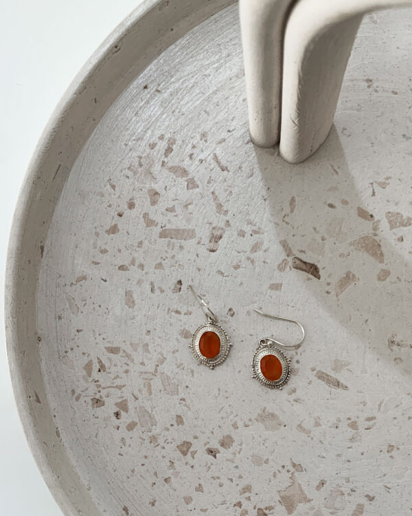 sterling silver earrings with a carnelian stone on a terrazzo tray