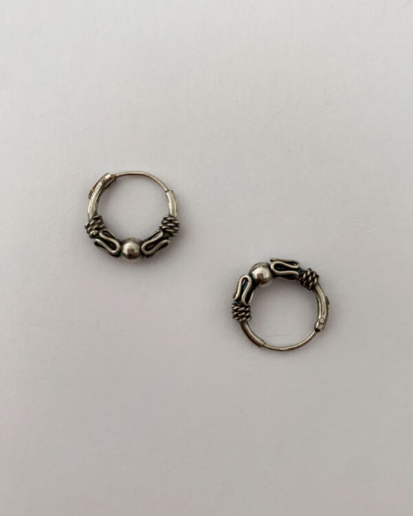 sterling silver hoop earrings with a bali design on a white background