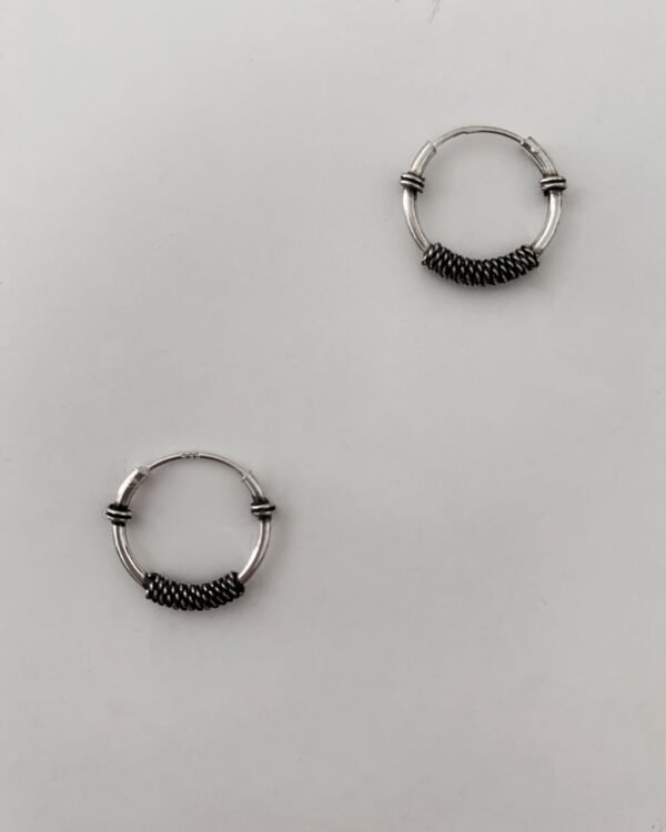 sterling silver hoop earrings with a bali design on a white background.