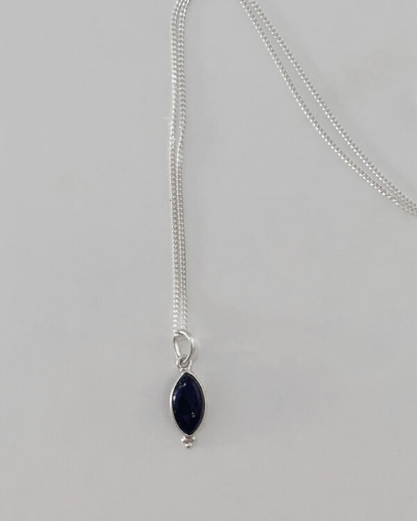 a lapis stone necklace with a sterling silver chain on a white background