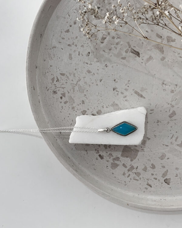 Aqua Chalcedony necklace on a white marble sitting on a terrazzo tray