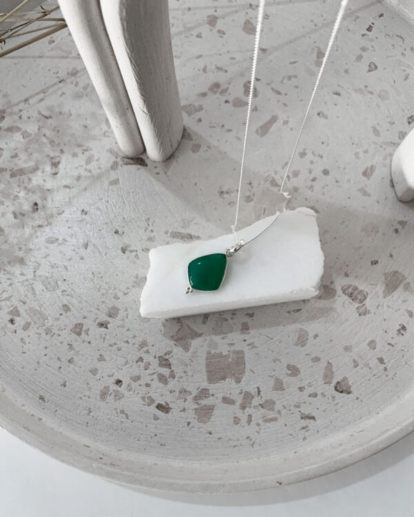 green onyx necklace on a terrazzo tray