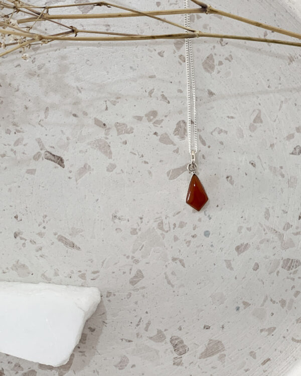 carnelian stone necklace on a terrazzo tray