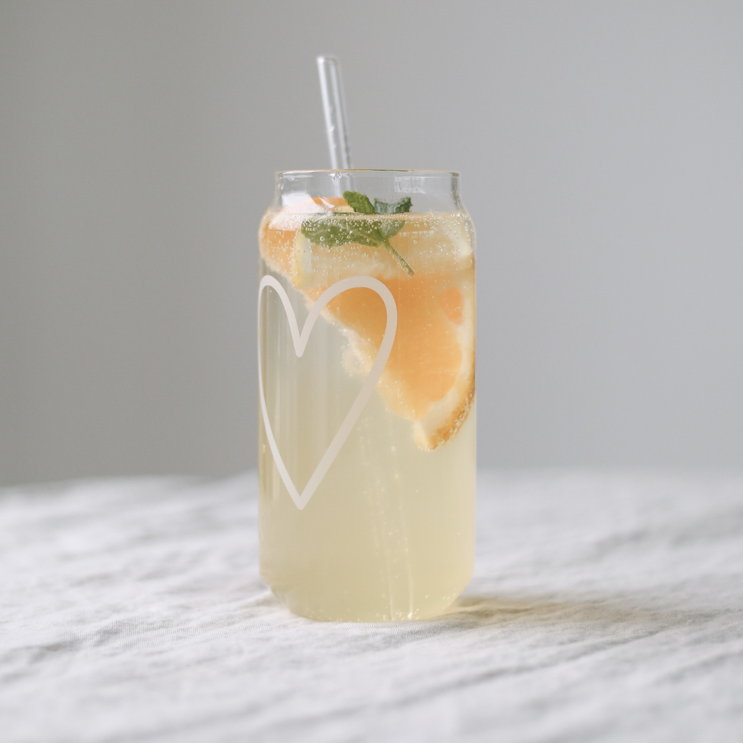 Introducing our new glasses with a heart print in white. Made from durable borosilicate glass, these stylish glasses are perfect for enjoying homemade lemonades, iced tea, summer cocktails, or milkshakes. With their unique can shape and large feel-good prints, they are absolute eye-catchers. Approx. 15 cm tall, 500 ml capacity, and dishwasher safe for easy cleaning.