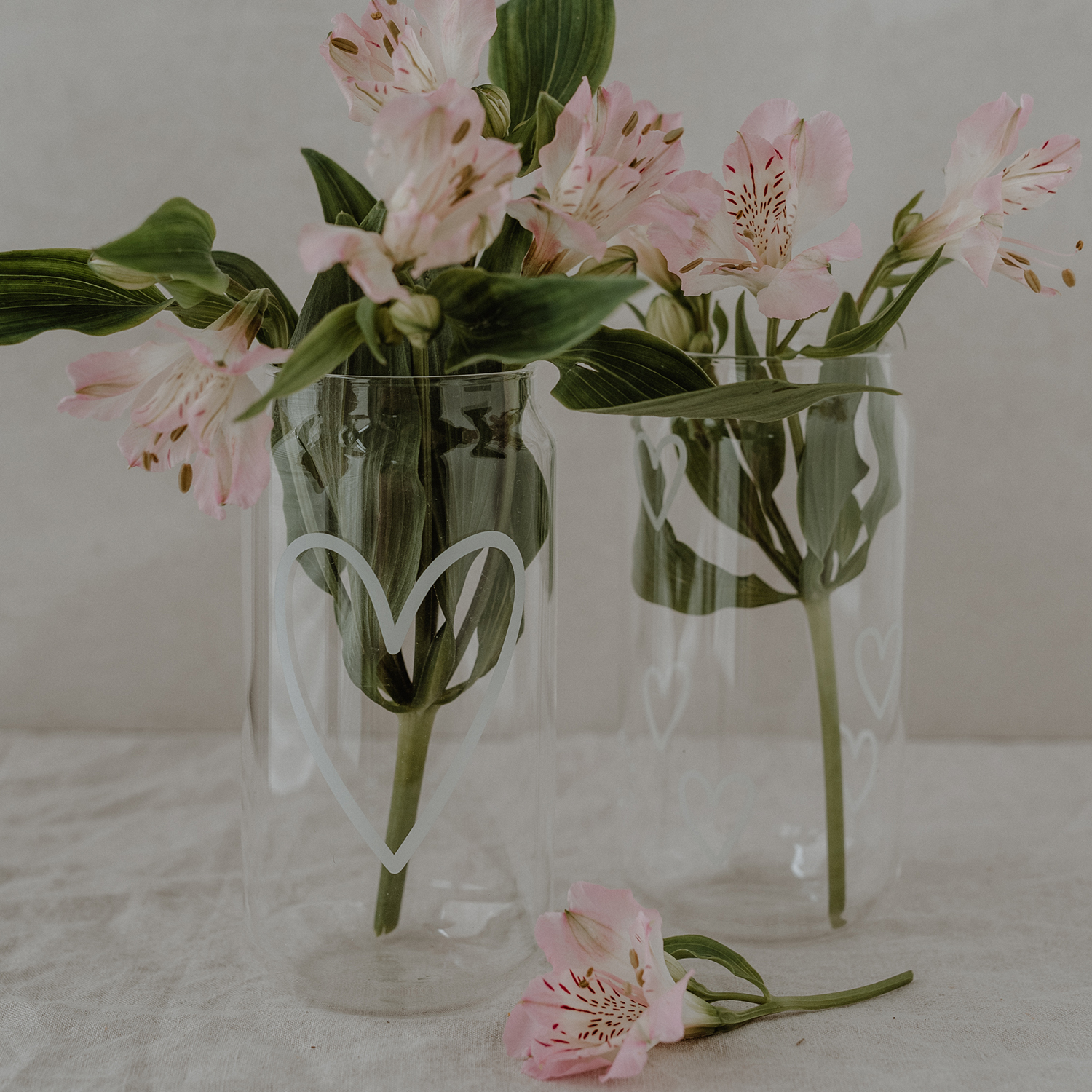 Introducing our new glasses with a heart print in white. Made from durable borosilicate glass, these stylish glasses are perfect for enjoying homemade lemonades, iced tea, summer cocktails, or milkshakes. With their unique can shape and large feel-good prints, they are absolute eye-catchers. Approx. 15 cm tall, 500 ml capacity, and dishwasher safe for easy cleaning.