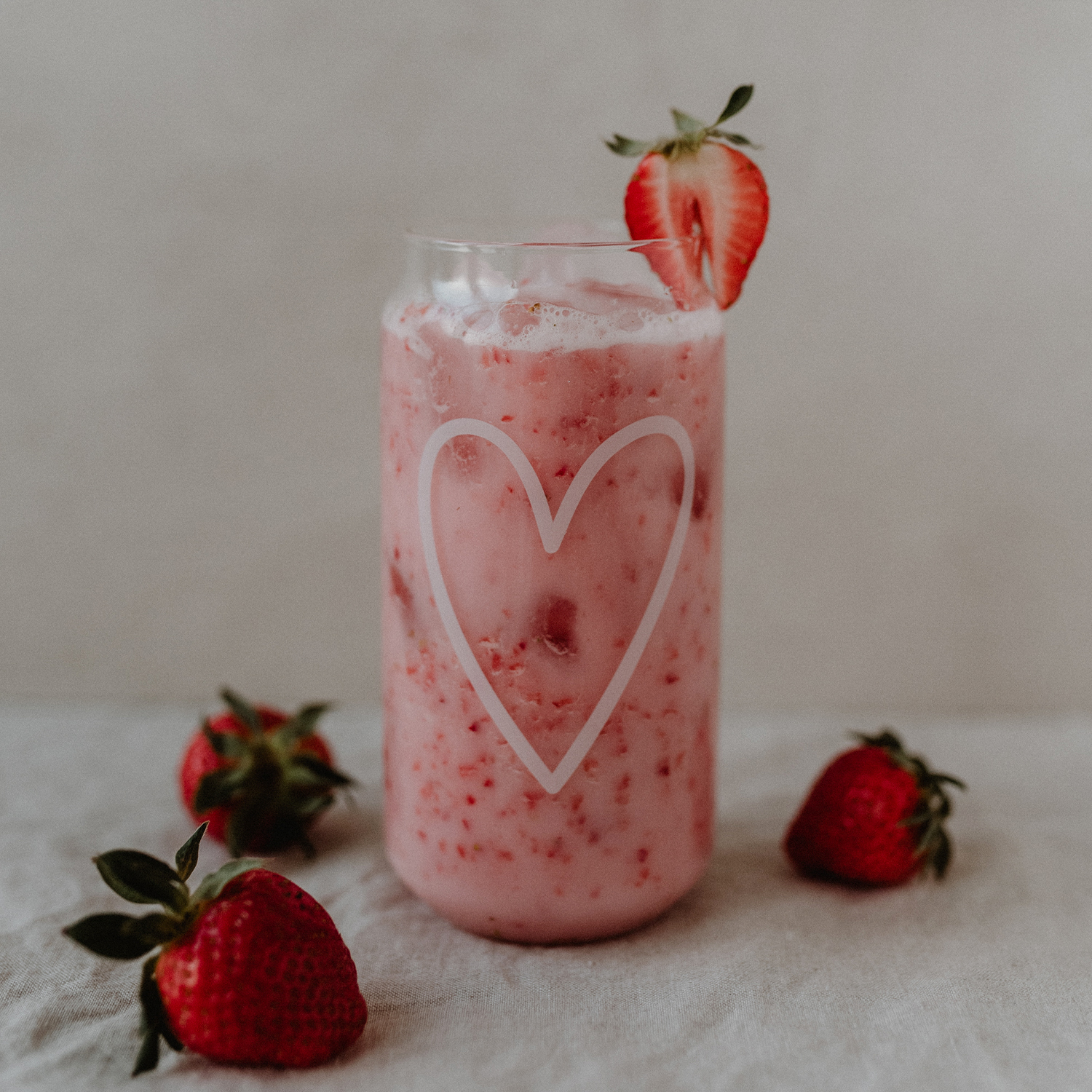 Introducing our new glasses with a heart print in white. Made from durable borosilicate glass, these stylish glasses are perfect for enjoying homemade lemonades, iced tea, summer cocktails, or milkshakes. With their unique can shape and large feel-good prints, they are absolute eye-catchers. Approx. 15 cm tall, 500 ml capacity, and dishwasher safe for easy cleaning.
