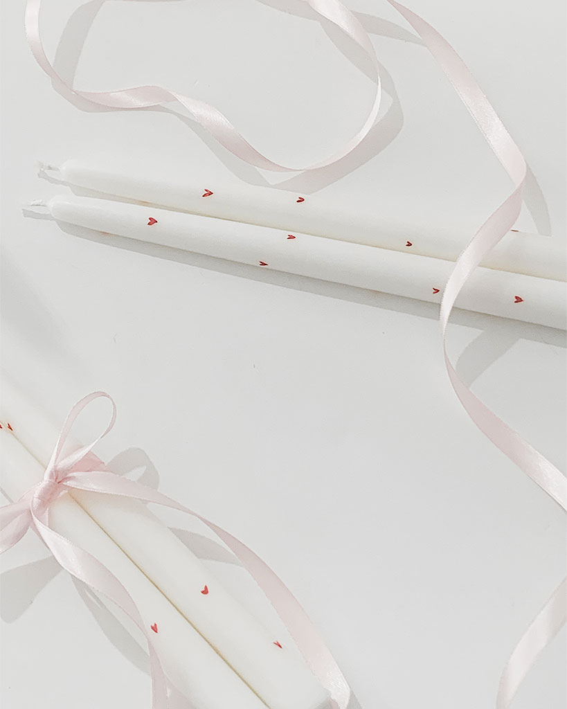Enamora Valentine's Collection: white candlesticks with red hearts. Burn time of 5.5h. Perfect for a romantic ambiance.