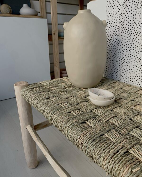 muted tones of beige vase sitting on a bench. boho decor. minimalistic or rustic.