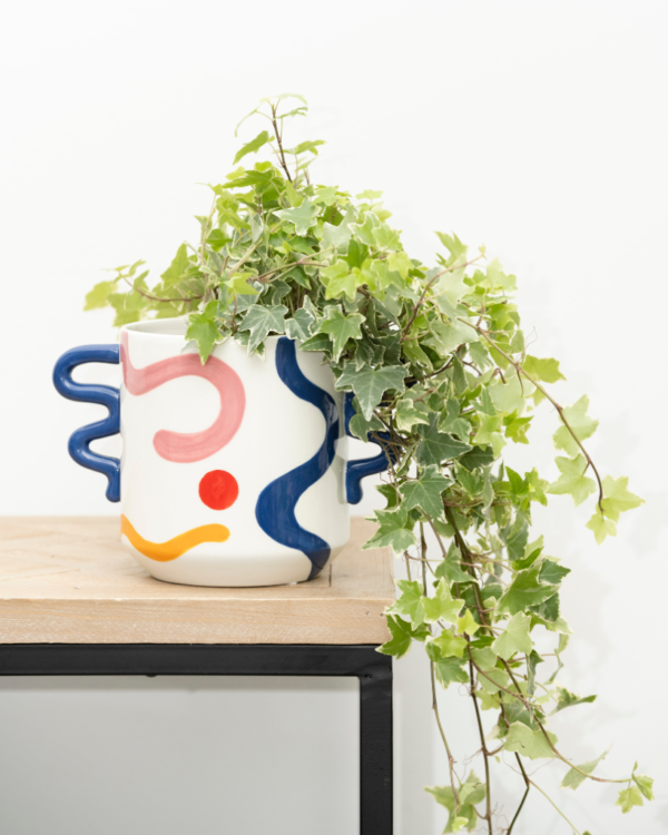 Add a vibrant twist to your plants with the ceramic Eva plant pot from Qué Rico. Designed in Belgium and infused with Spanish inspiration, this planter, adorned with the Pintura Locura pattern, is the perfect home for your leafy friends. With its organic shape and funky colour combination of blue, red, yellow and pink, this handcrafted planter is a true eye-catcher in any interior. As it is hand-painted, every piece is unique! Gift packaging included.