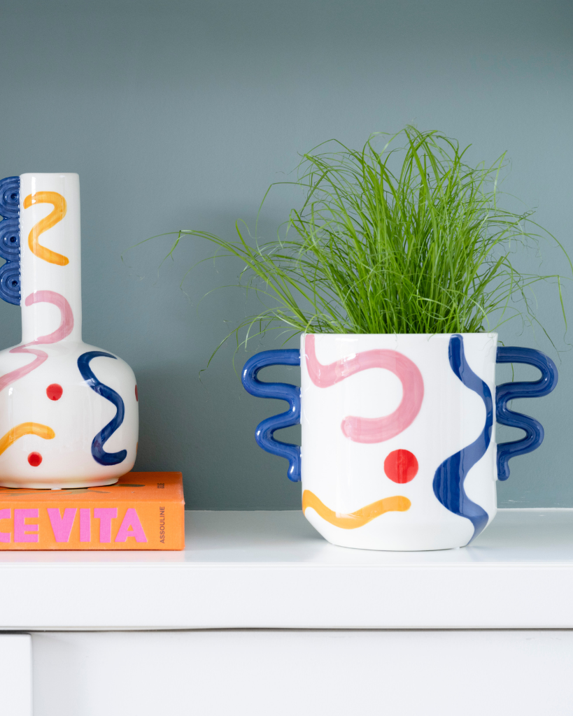 Add a vibrant twist to your plants with the ceramic Eva plant pot from Qué Rico. Designed in Belgium and infused with Spanish inspiration, this planter, adorned with the Pintura Locura pattern, is the perfect home for your leafy friends. With its organic shape and funky colour combination of blue, red, yellow and pink, this handcrafted planter is a true eye-catcher in any interior. As it is hand-painted, every piece is unique! Gift packaging included.
