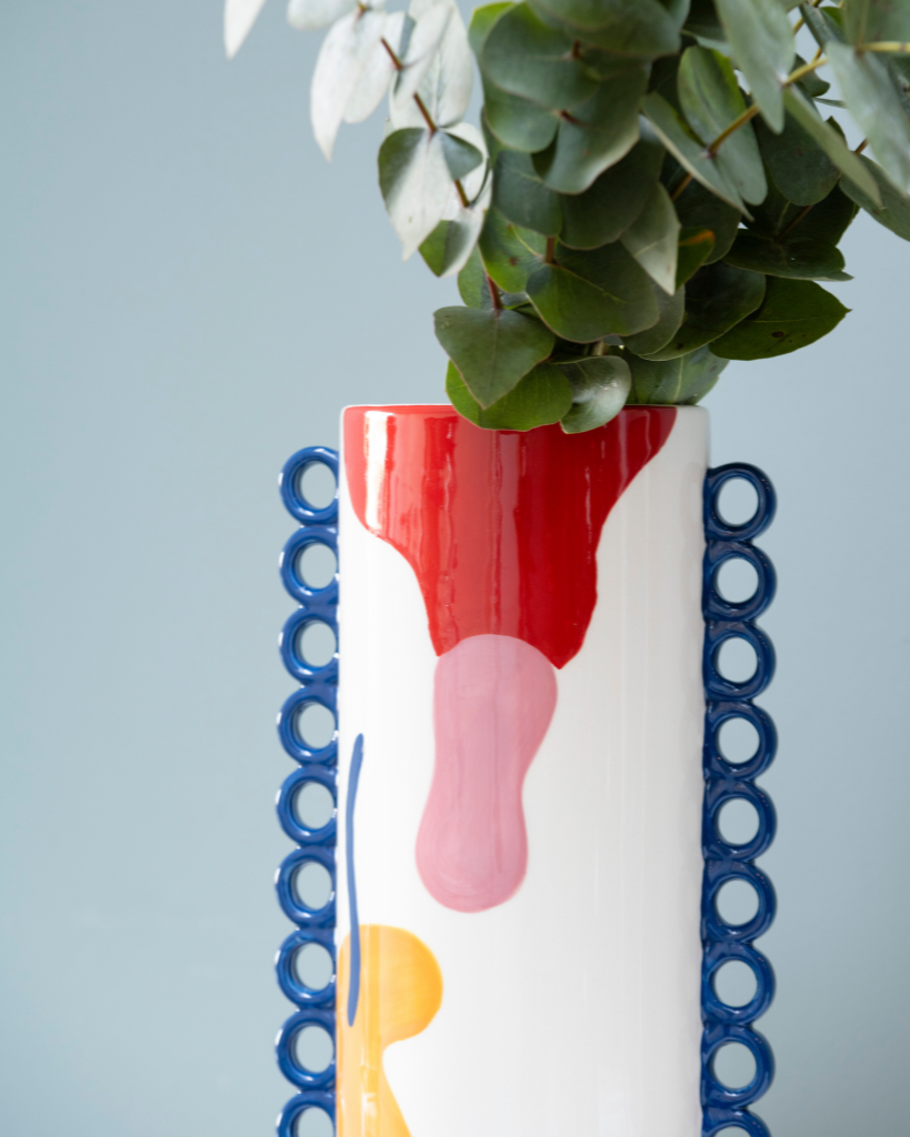 Enhance your floral display with the ceramic Cloé vase from Qué Rico. This Belgian-designed vase, inspired by the lively Spanish lifestyle and featuring the colourful Funky y Feliz pattern, adds a ray of sunshine to your home. With its organic shape and funky colour combination, this handmade vase is a true eye-catcher in any interior. As it is hand-painted, every piece is unique! Gift packaging included.