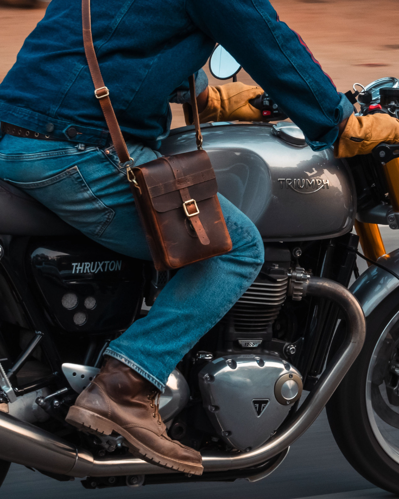 Premium leather sling bag with quick-release mounting (motorcycle compatible), one-click opening, and included rain cover. Handcrafted and built to last, developing a unique patina over time. Perfect for everyday carry and more.