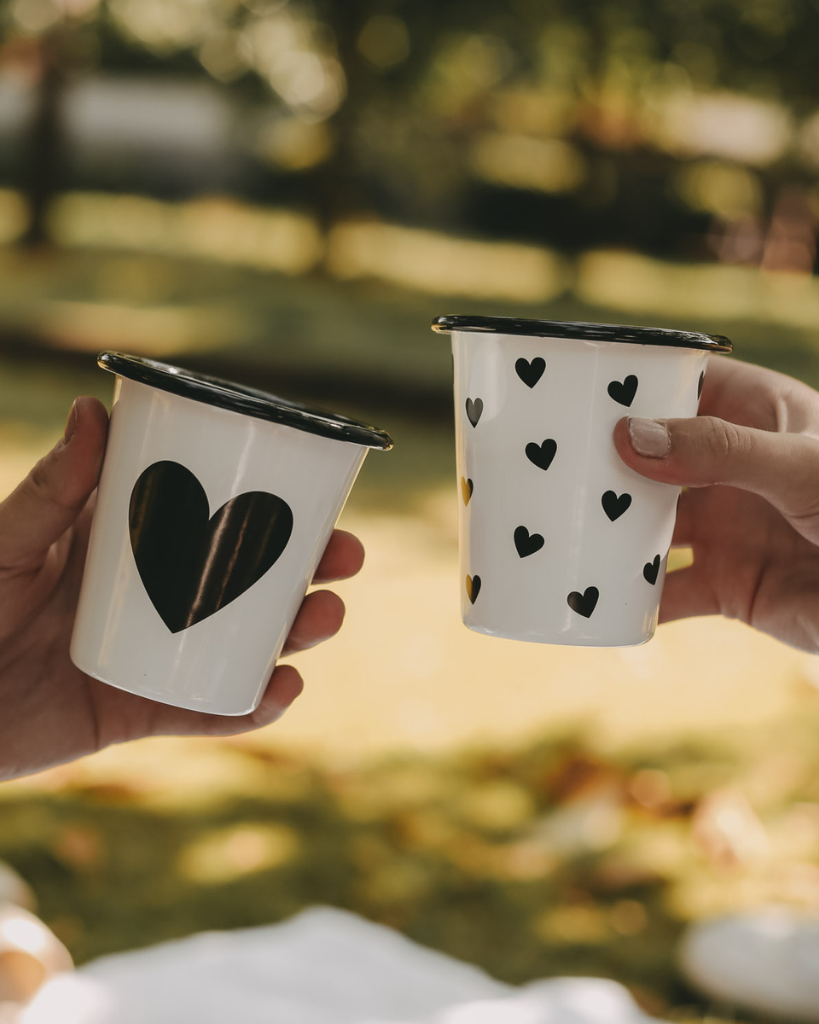 Heart Pattern Enamel Camping Mug | 290ml | Outdoor & Camping Essential Add joy to your outdoor adventures with this charming enamel mug featuring delicate black hearts. Built tough for camping and picnics, this 290ml mug combines vintage style with modern durability. Dishwasher safe and easy to clean, it's perfect for hot drinks around the campfire or backyard gatherings. The sturdy enamel construction ensures long-lasting use while its compact size (9cm x 8.6cm) makes it ideal for camping kits and outdoor dining.