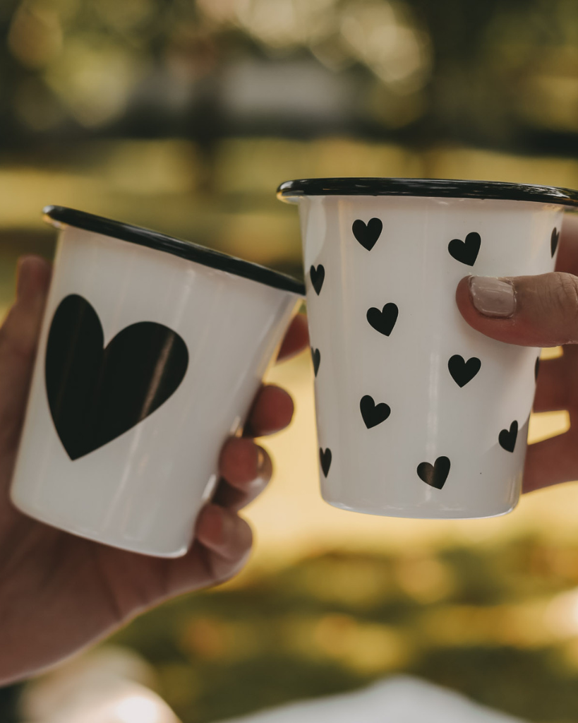 Heart Pattern Enamel Camping Mug | 290ml | Outdoor & Camping Essential Add joy to your outdoor adventures with this charming enamel mug featuring delicate black hearts. Built tough for camping and picnics, this 290ml mug combines vintage style with modern durability. Dishwasher safe and easy to clean, it's perfect for hot drinks around the campfire or backyard gatherings. The sturdy enamel construction ensures long-lasting use while its compact size (9cm x 8.6cm) makes it ideal for camping kits and outdoor dining.