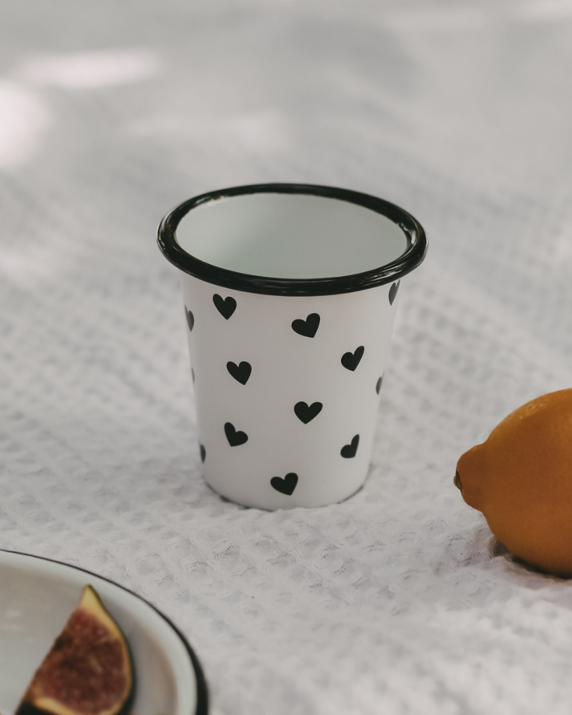 Heart Pattern Enamel Camping Mug | 290ml | Outdoor & Camping Essential Add joy to your outdoor adventures with this charming enamel mug featuring delicate black hearts. Built tough for camping and picnics, this 290ml mug combines vintage style with modern durability. Dishwasher safe and easy to clean, it's perfect for hot drinks around the campfire or backyard gatherings. The sturdy enamel construction ensures long-lasting use while its compact size (9cm x 8.6cm) makes it ideal for camping kits and outdoor dining.