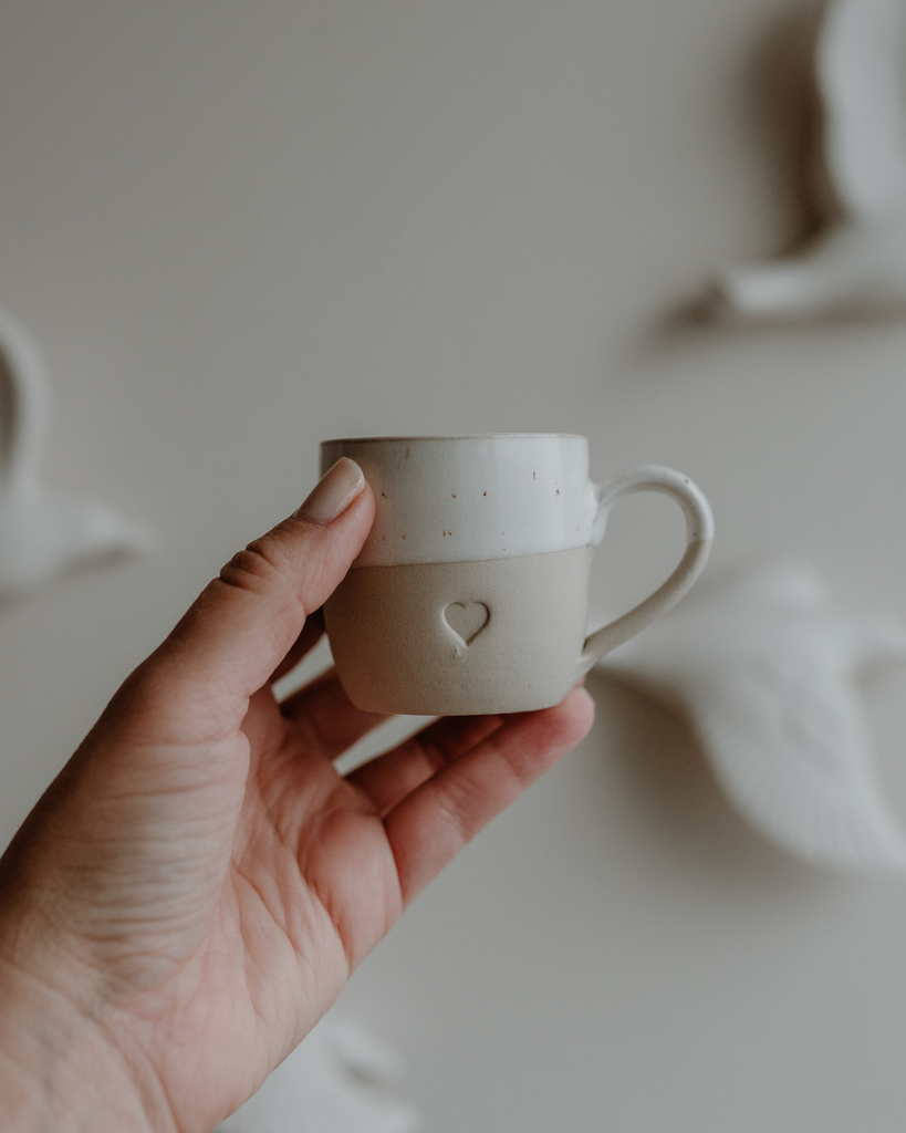 Sip with love from our handcrafted espresso cup featuring a subtle blind embossed heart design and practical handle. Unique stoneware charm. Dishwasher and microwave safe. Capacity: 60 ml (usable), 80 ml (full).