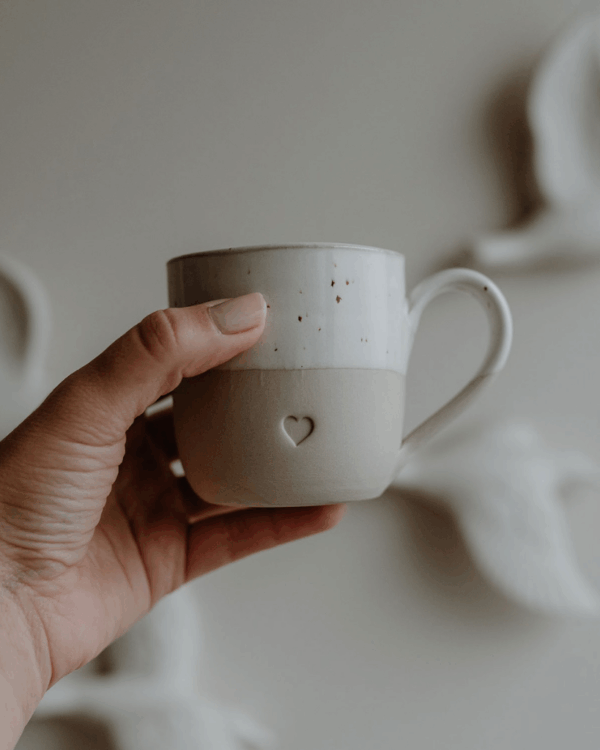 Discover your perfect cappuccino cup! Our handmade stoneware mug features a signature blind embossed heart design and ideal capacity for your favorite coffees. Dishwasher and microwave safe. Capacity: 150 ml (usable), 190 ml (full).