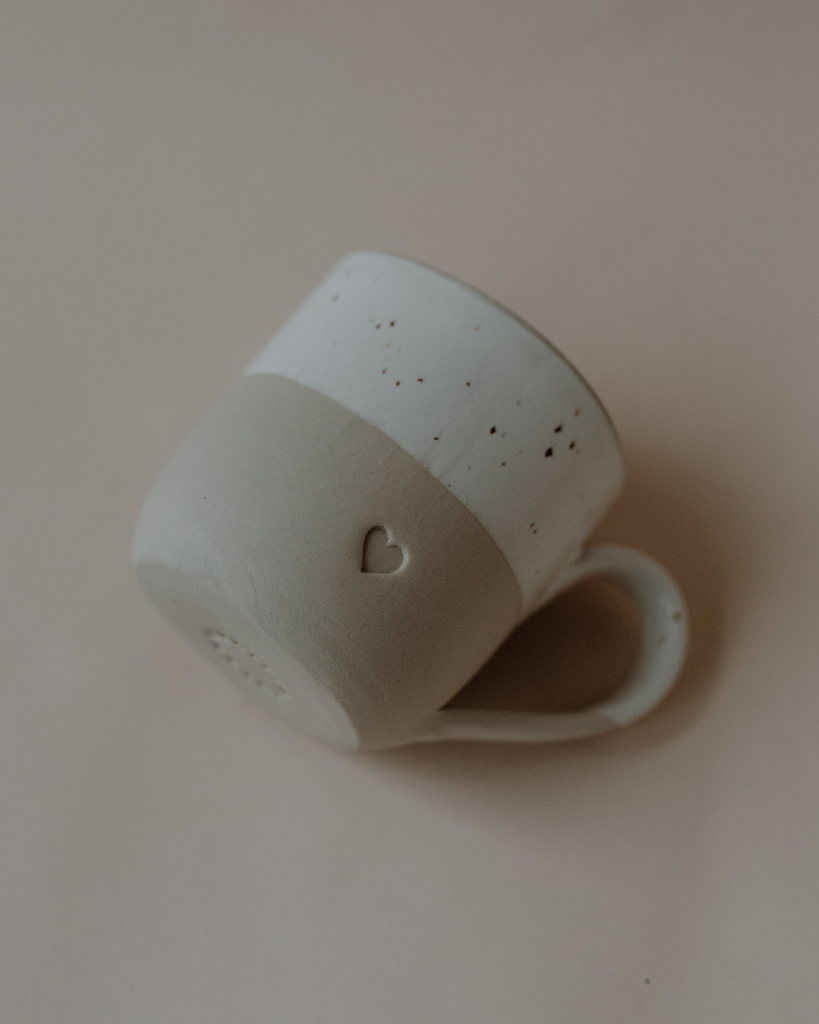 Discover your perfect cappuccino cup! Our handmade stoneware mug features a signature blind embossed heart design and ideal capacity for your favorite coffees. Dishwasher and microwave safe. Capacity: 150 ml (usable), 190 ml (full).