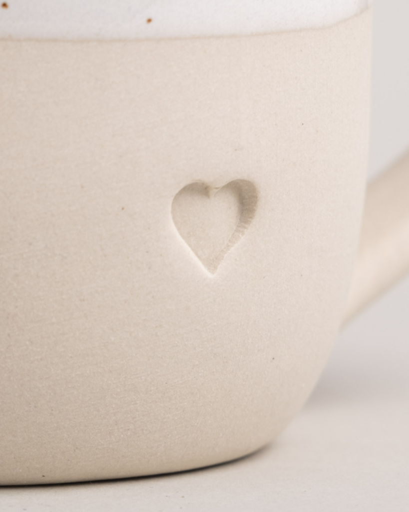 Discover your perfect cappuccino cup! Our handmade stoneware mug features a signature blind embossed heart design and ideal capacity for your favorite coffees. Dishwasher and microwave safe. Capacity: 150 ml (usable), 190 ml (full).