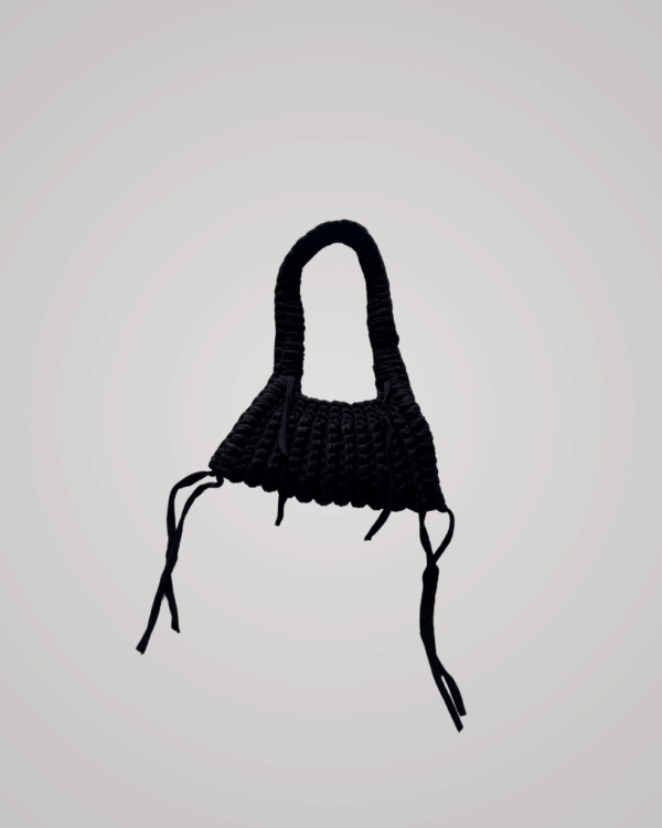 This handcrafted black crochet bag combines style and function. Made from soft t-shirt yarn, it easily transitions from shoulder to handbag.