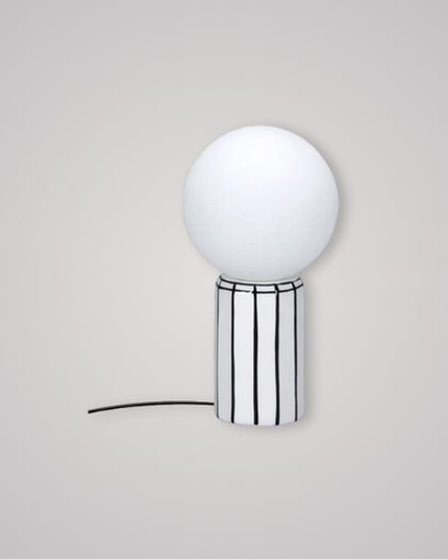 Small porcelain lamp with black vertical lines and a satin white globe on top.